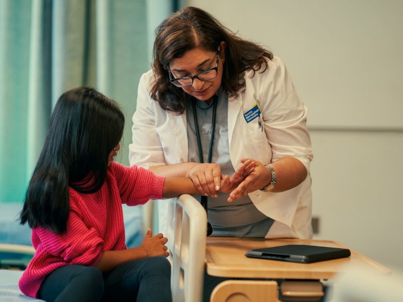 A female doctor examines a little girls arm