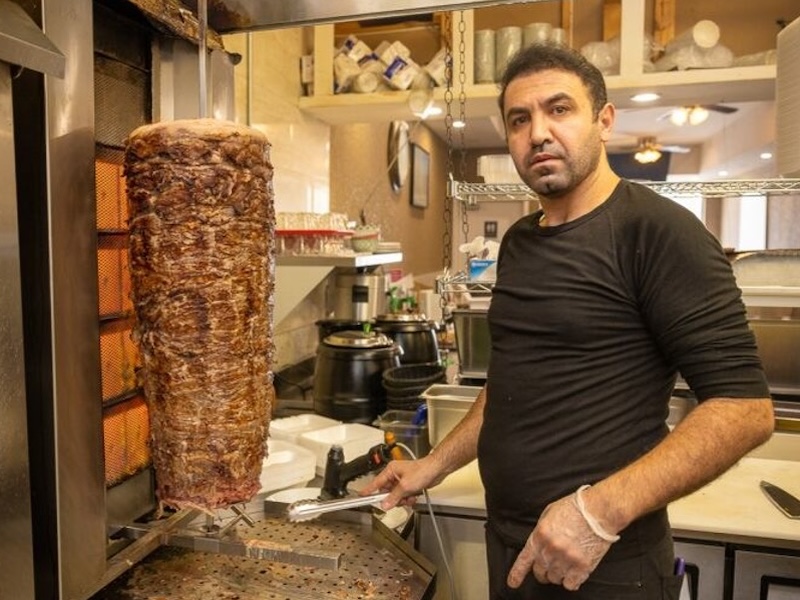 A cook cutting shawarma meat 