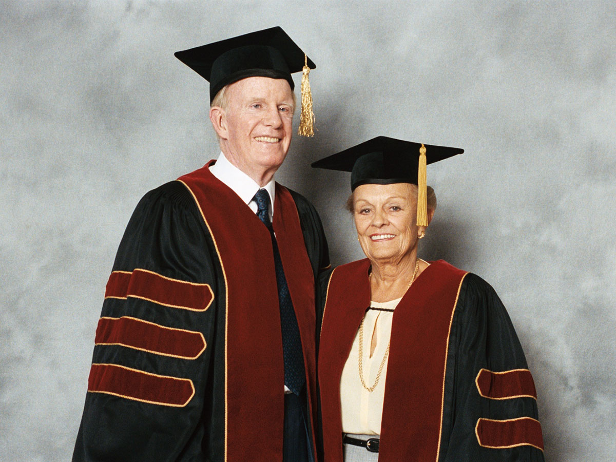 Ted (left) and Loretta Rogers pose in convocation robes the day they receive honorary doctorates from Toronto Metropolitan University. (Photograph Courtesy of Toronto Metropolitan University Archives)