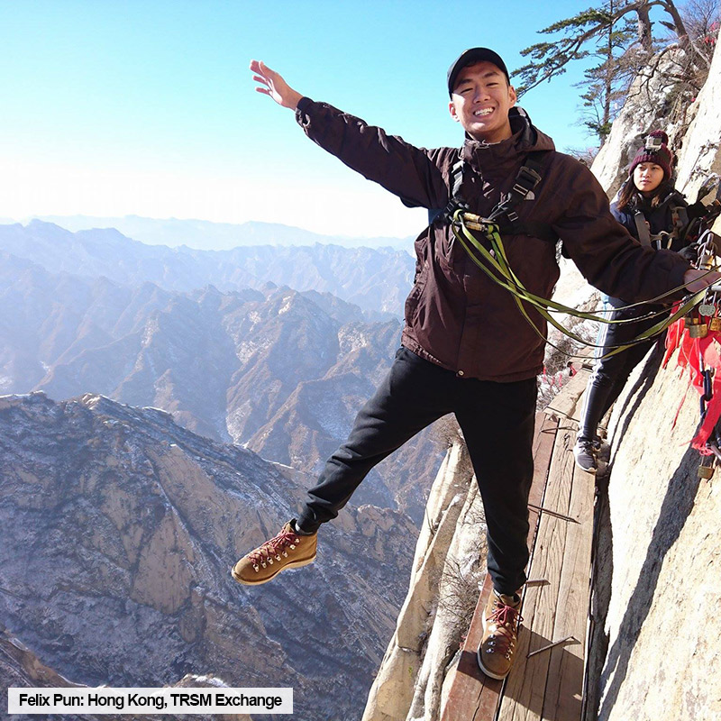 Toronto Metropolitan University TRSM student, Felix Pun, poses on the side of a mountain while on exchange in Hong Kong.