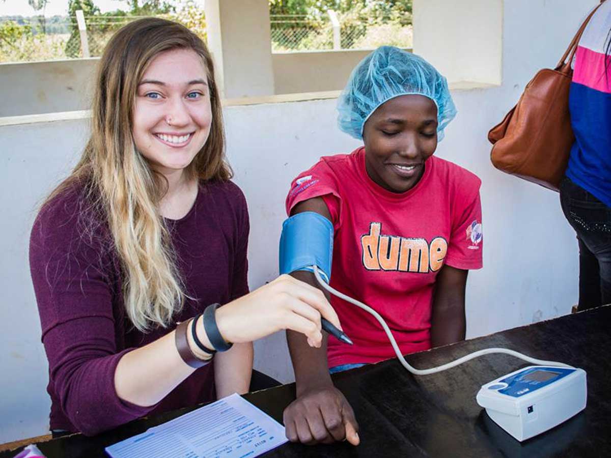 From left: Emily Nicholishen tests a woman’s vitals