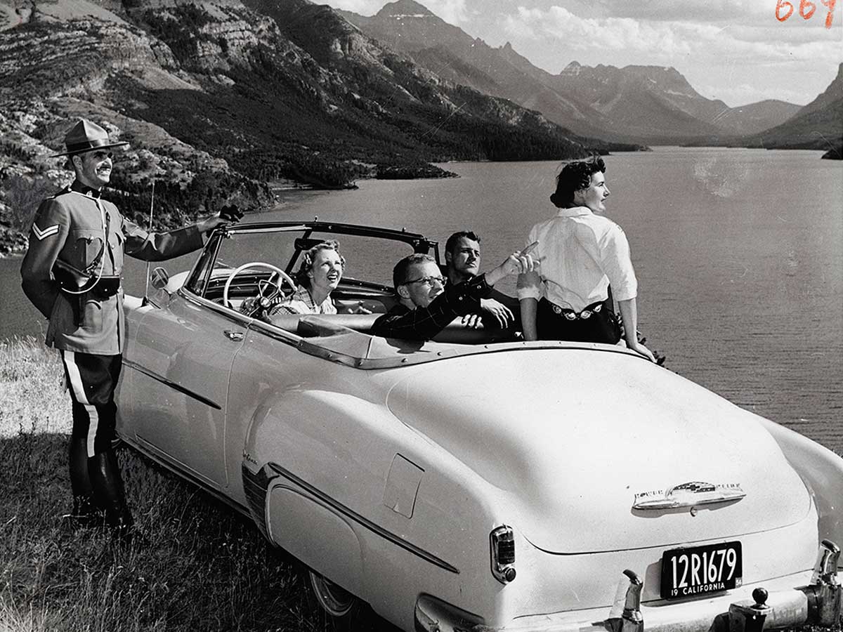 Gar Lunney, [Corporal W.W. MacLeod of the Royal Canadian Mounted Police gives directions to tourists in Waterton Lakes National Park, Alberta], ca. 1958, gelatin silver print. The Rudolph P. Bratty Family Collection, Ryerson Image Centre