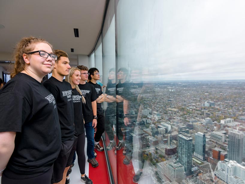Residence students looking out the window at the top of the CN Tower