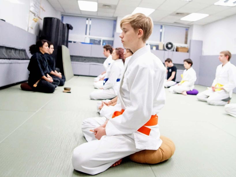 Children practicing meditation with their sensei 
