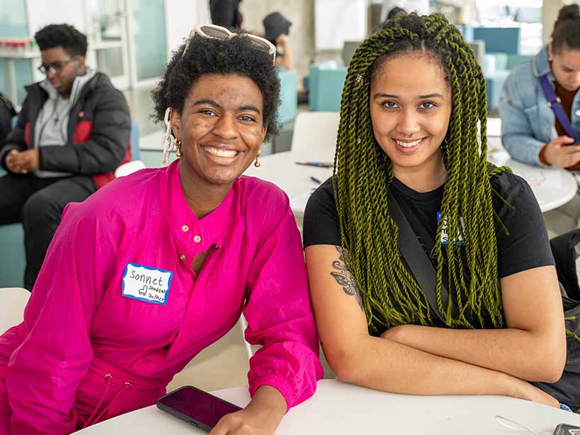  Two Black students smiling at an event.