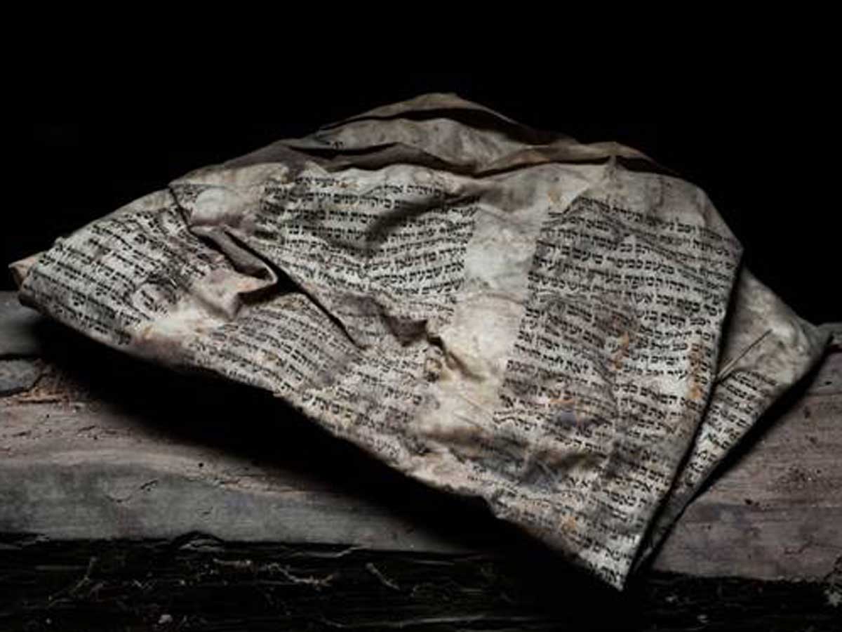 An old, worn out, crumpled page of a Hebrew text