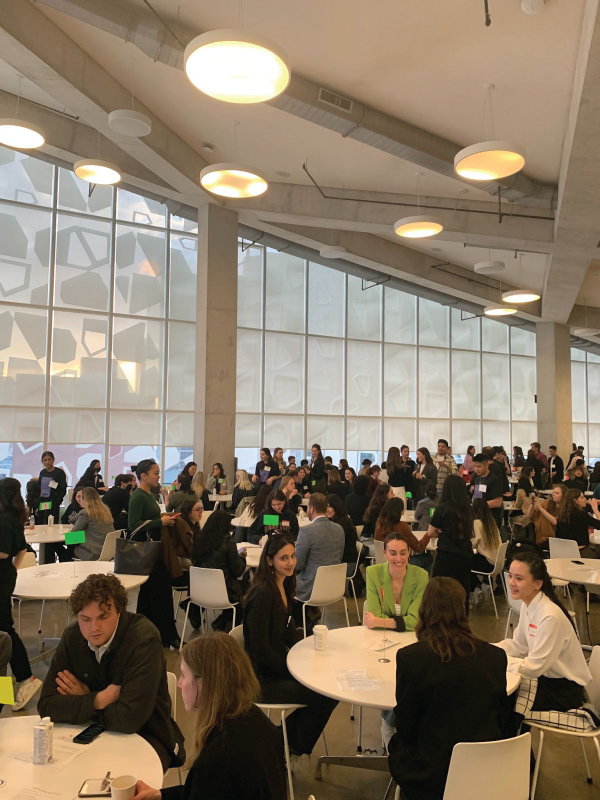 Participants sit around multiple tables throughout the room to take part in speed networking.