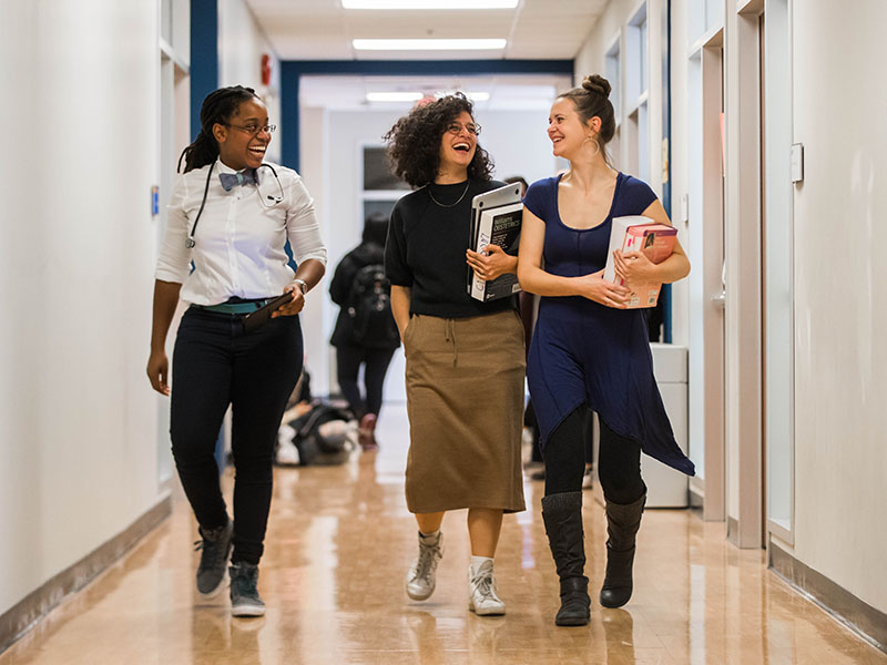 Three midwifery students walking down hallway