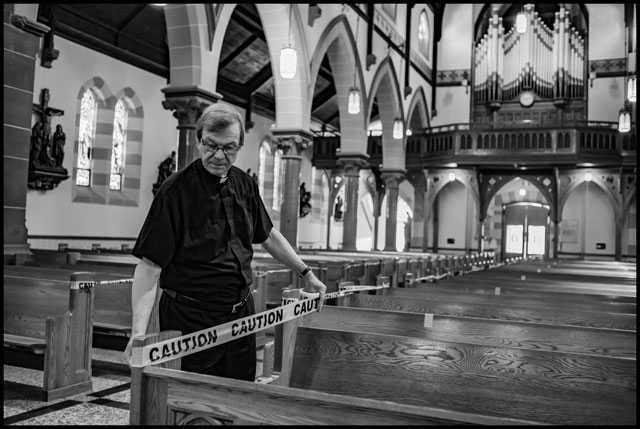Father Fernando at St. Mary’s Church prepares the social distance seating using caution tape. Photo George Pimentel.