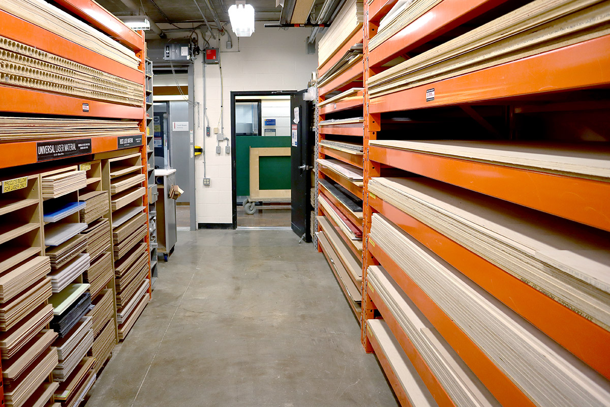 Multiple types of wood sheets are located in industrial shelving units. 