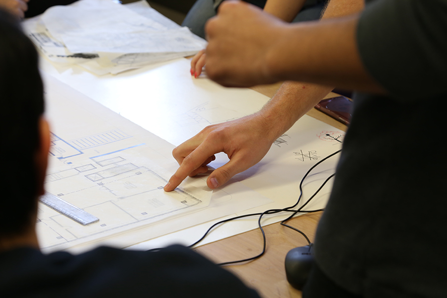 Professionals surrounding a blueprint on a desk