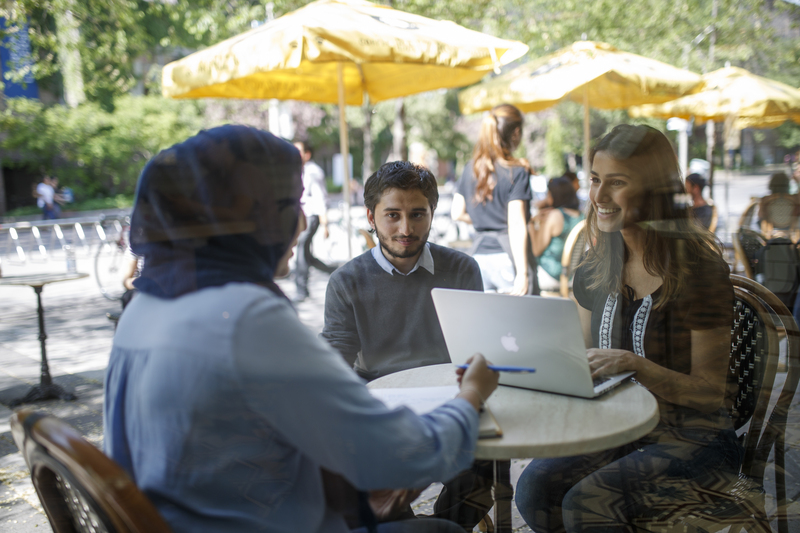 Three students work at a table at Balzac's coffee shop on campus.