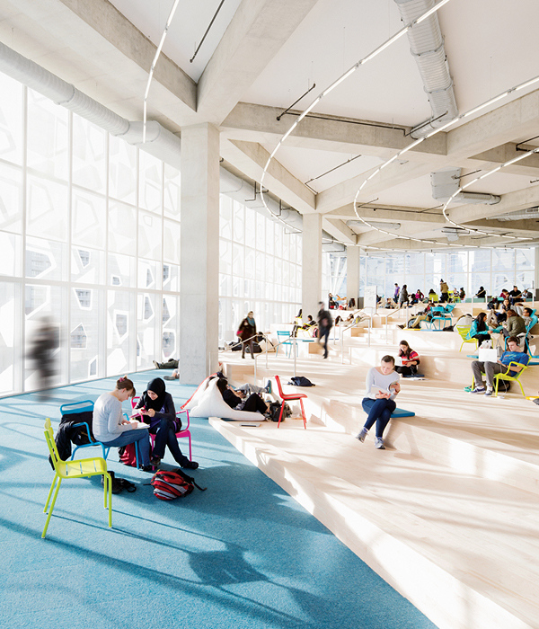 A bright and airy photo of some students sitting on chairs and others on the steps at
the Student Learning Centre on a level called The Beach.
