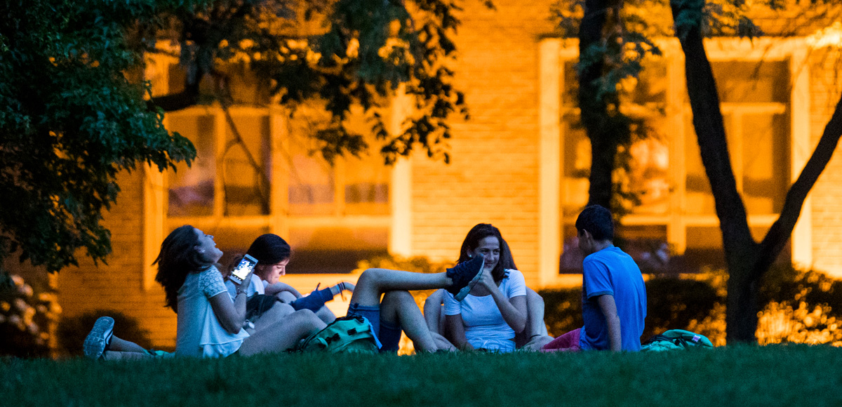 Students sitting in a circle in the quad, laughing.