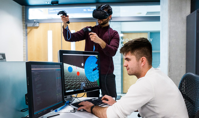 Computer science graduate studies students working in the VR lab.