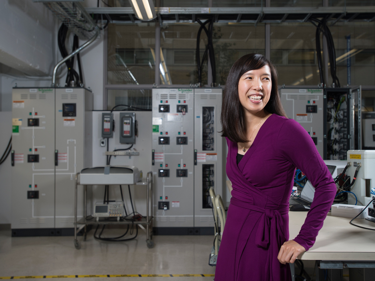 A female with a purple dress is standing in the Schneider Electric Smart Grid Laboratory.