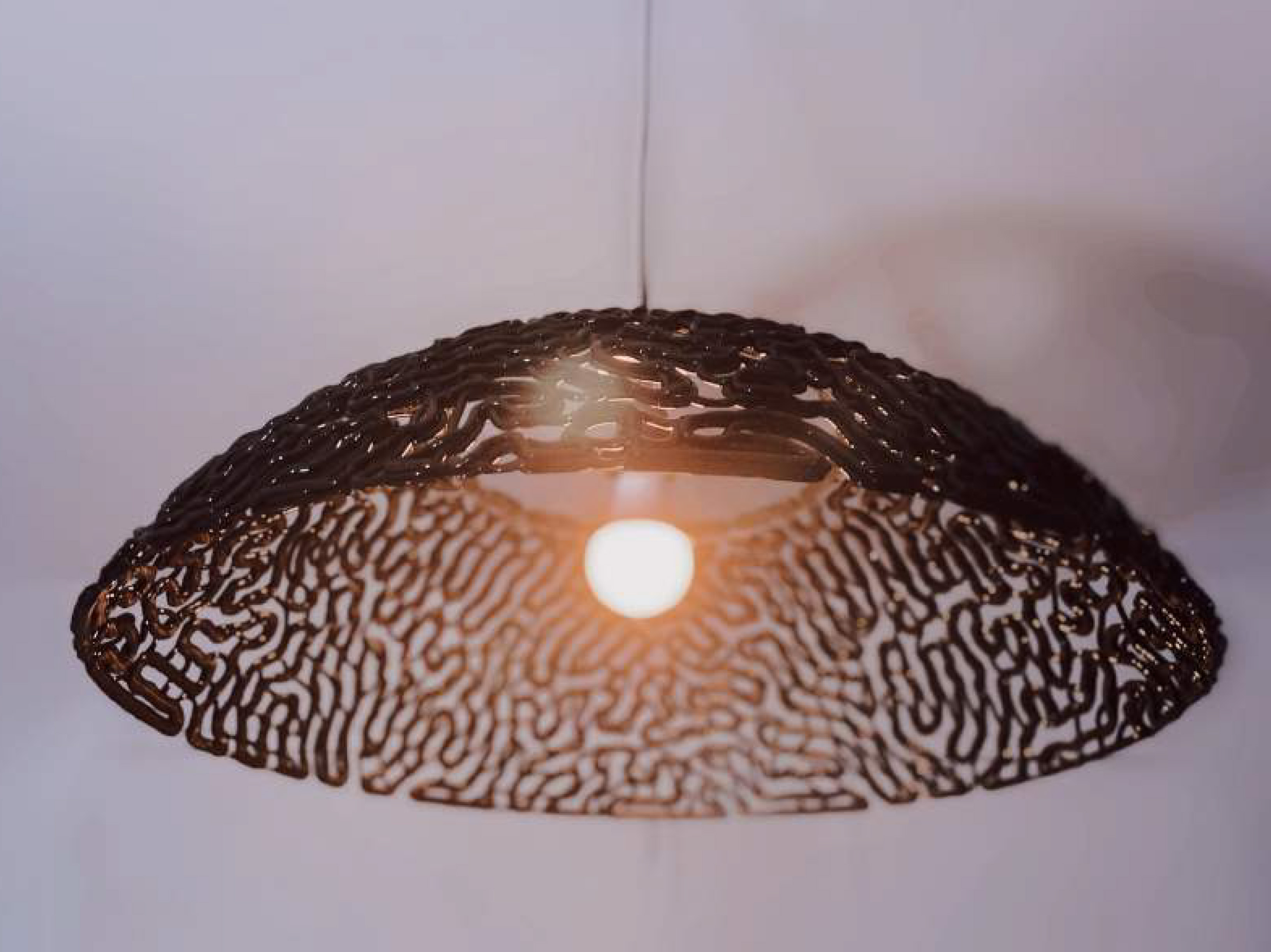 Intricate 3D printed dome-shaped lampshade, hanging from a cable.