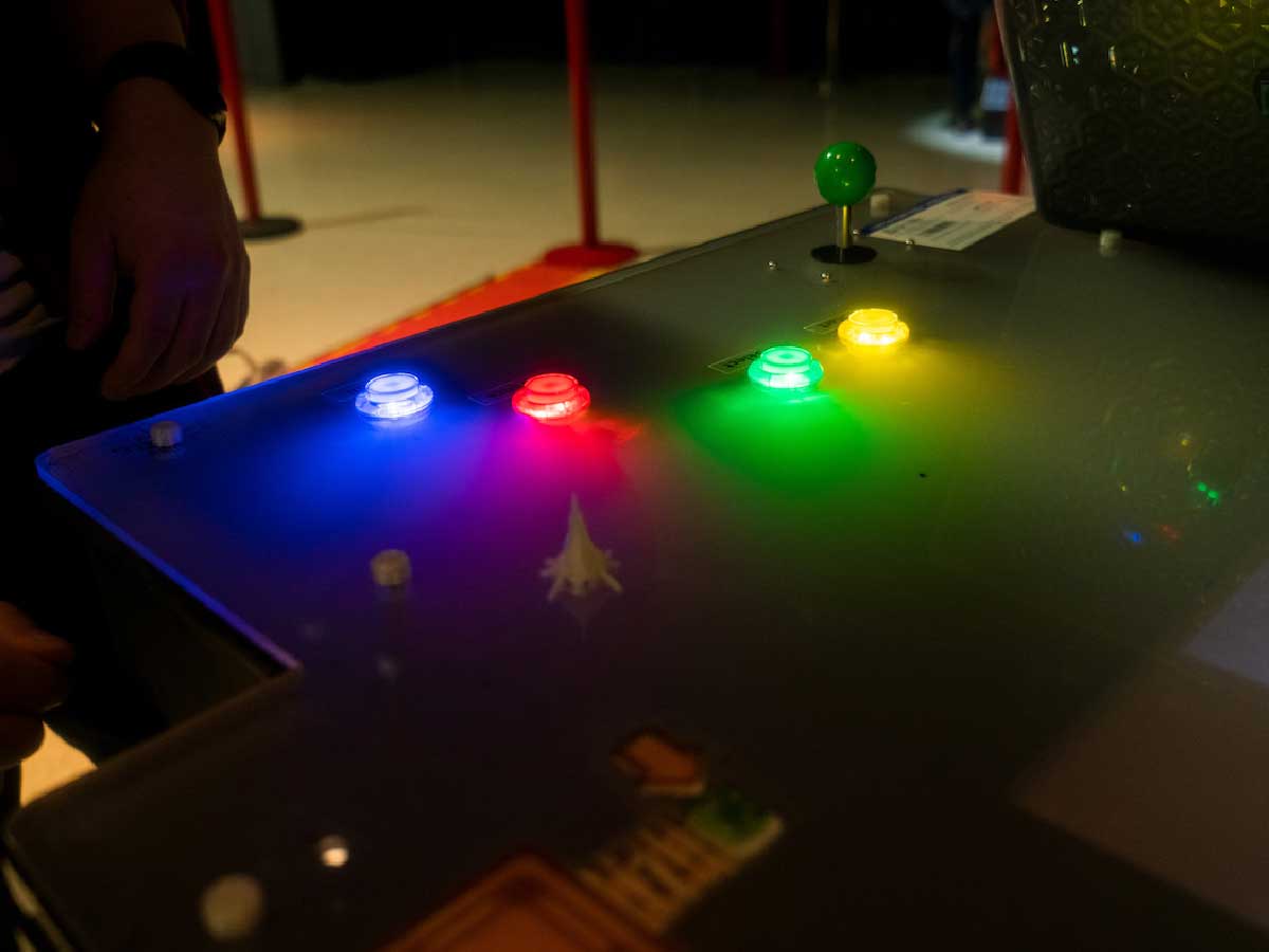 4 objects are gliowing different colours on top of a dark table. 