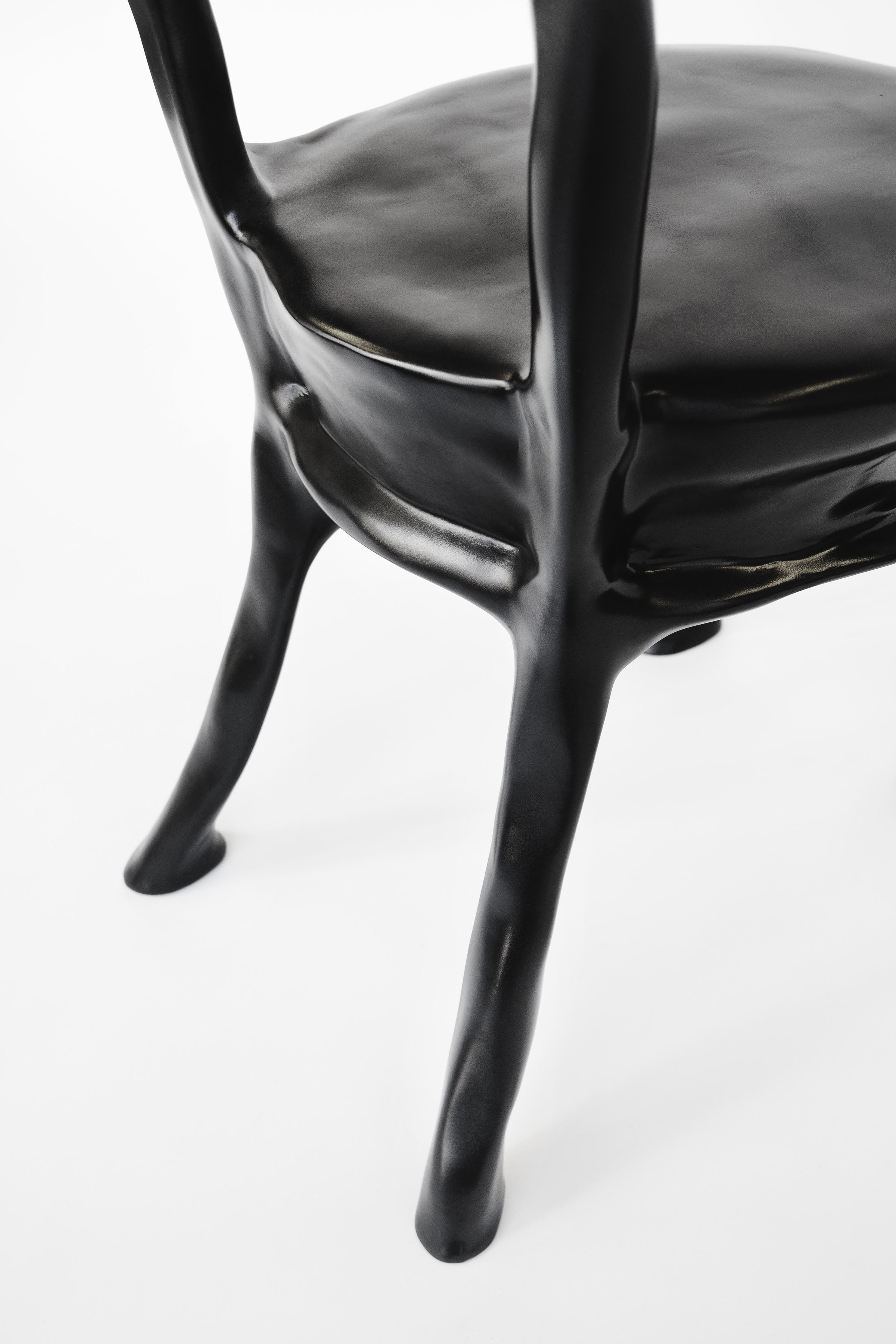 A glossy black chair with warbled surface texture. 
