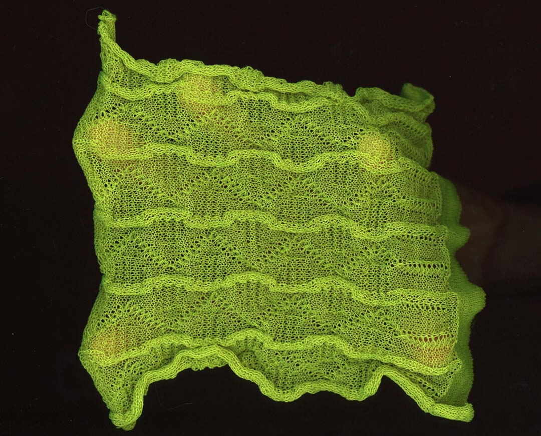 A neon green knit piece, resembling a wavy pattern. 