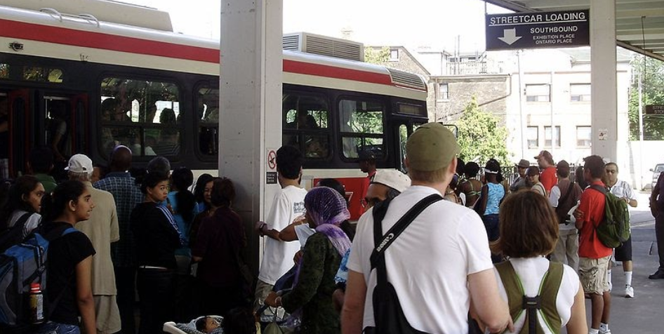 Torontonians await a streetcar during pre-COVID busyness. Via Wikimedia Commons.