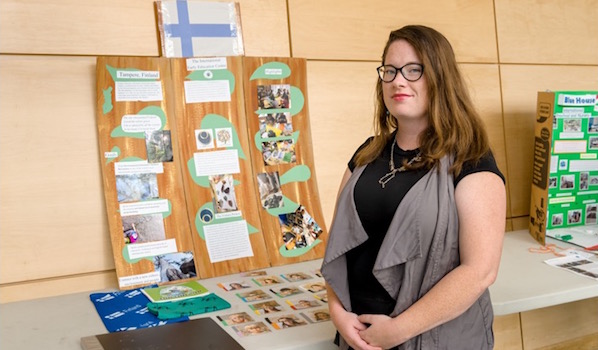 Shawna Lee Campbell is standing near the banner of The International Early Education Centre, Finland