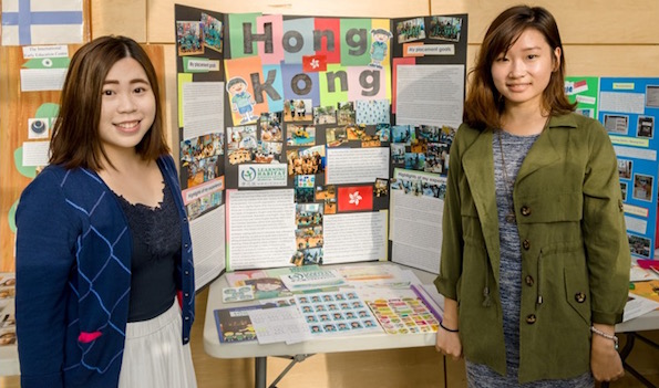Jade Law and Candace Chan are standing near the banner of the Learning Habitat, Hong Kong 