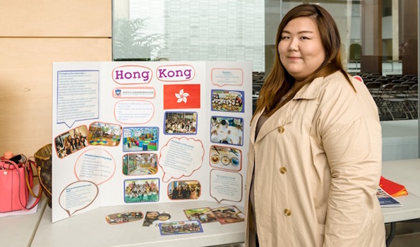 Wai Shan Tiffany Ore is standing near the banner of Mang San Kindergarten, Hong Kong