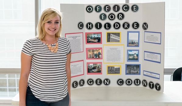 Kristina Cosentino is standing near the banner of the Office for Children, New Jersey