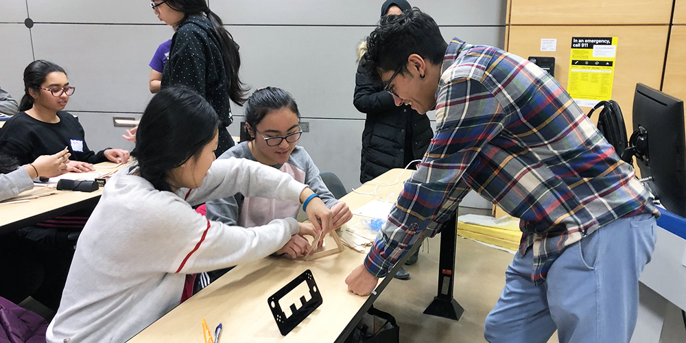A group of three high-school students participating in an engineering workshop