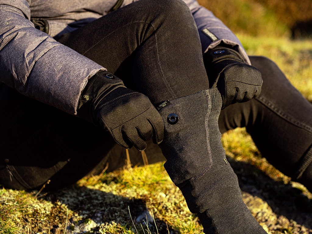 A man wears Quanta Vici heated gloves and socks outdoors