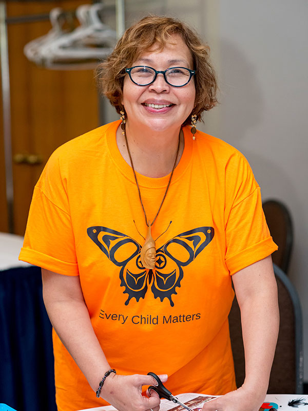 Monica McKay in an orange shirt that reads "Every child matters"