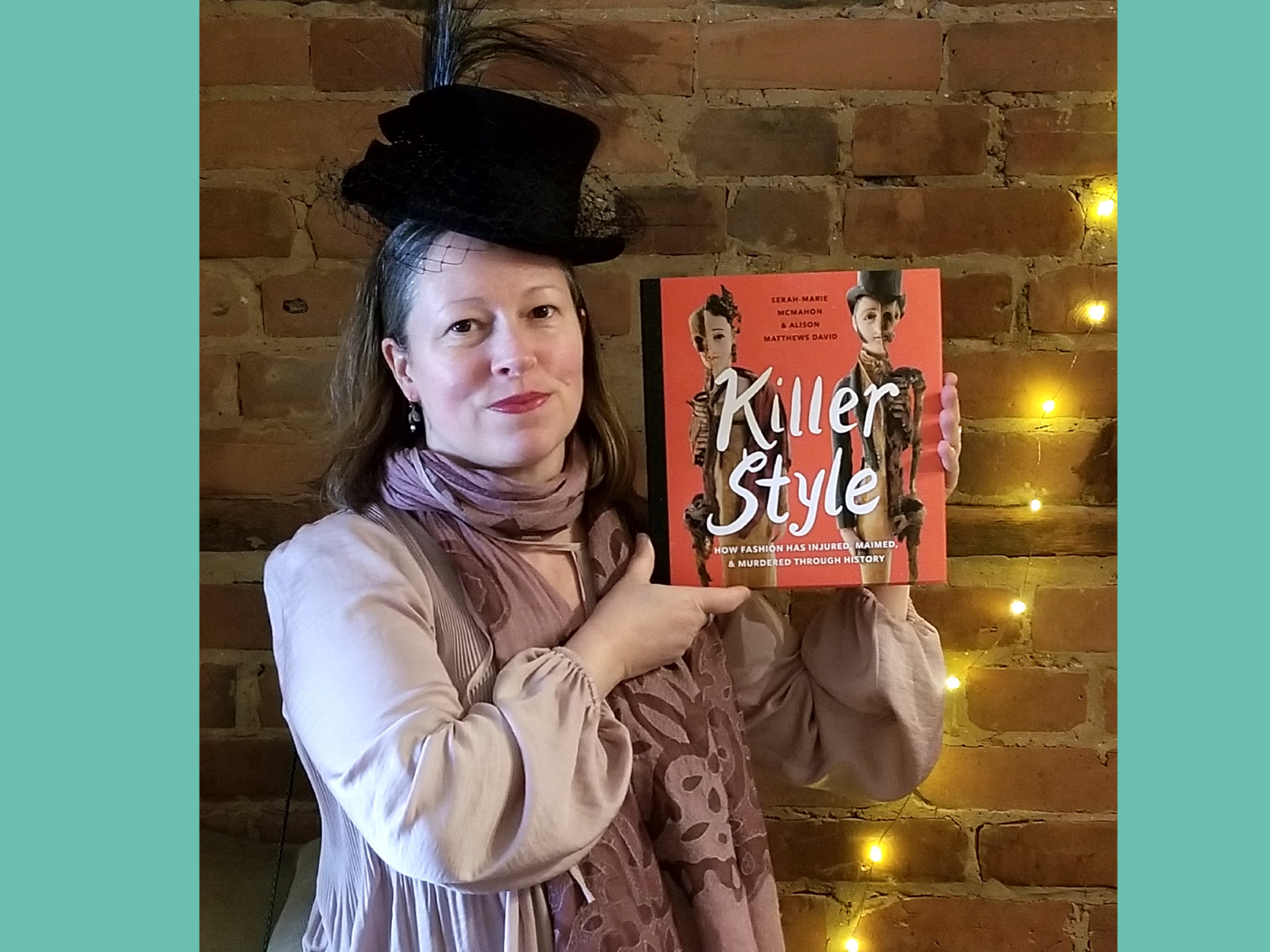 Dr. Alison Matthews David holding her book, Killer Style, at the launch