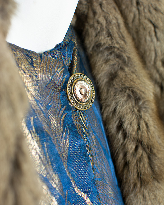 Close up of gold button on 1920s brocade opera coat