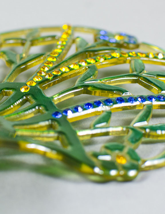 Green celluloid hair comb with yellow and blue accents
