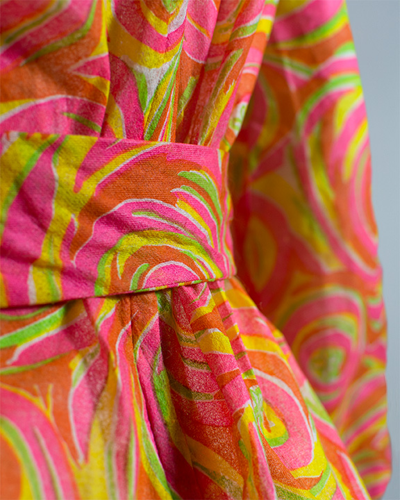 Close up of belt detail of pink, orange, yellow and green swirly patterned paper jumpsuit