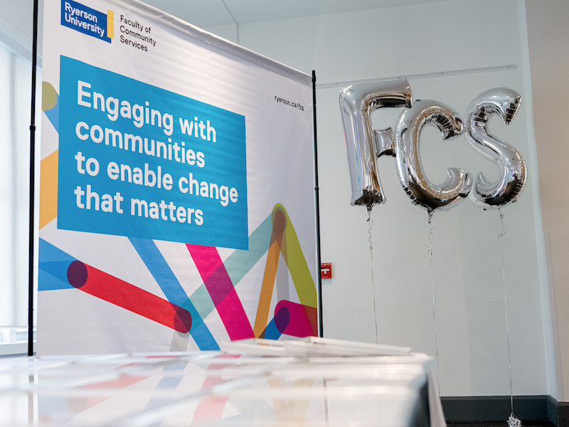 Colourful banner reading 'Engaging with communities to enable change that matters' next to Metallic letter balloons reading 'FCS'