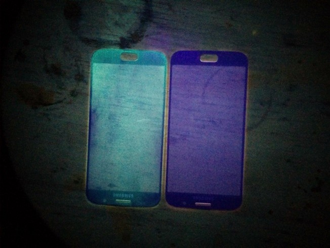 iPhones coated with an antimicrobial compound shown with UV light