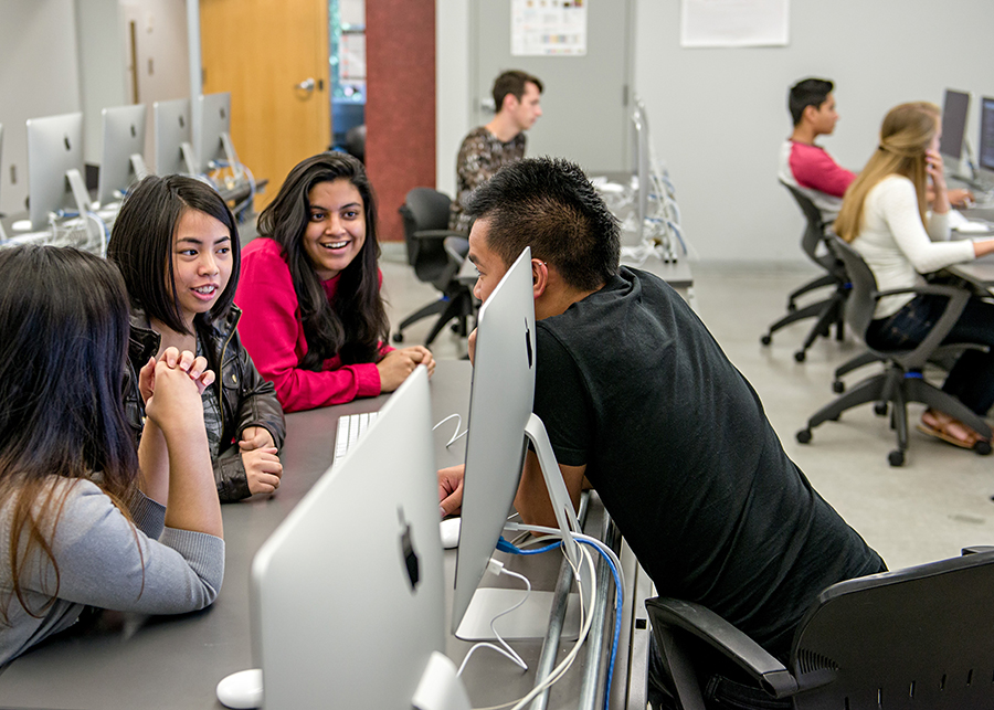 Students having a discussion in the Mac lab.