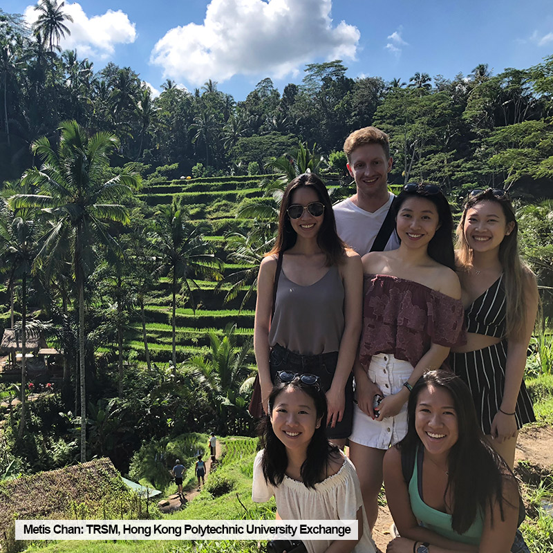 Toronto Metropolitan University TRSM student, Metis Chan, poses with friends in front of a rice field while on exchange at Hong Kong Polytechnic University.