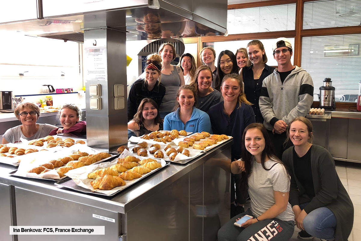 Toronto Metropolitan University FCS student, Ina Benkova, poses with pastries and group of students in a kitchen during a summer course and internship in France.