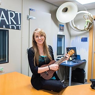 Ella Dubinsky, Psychology MA student, holding guitar