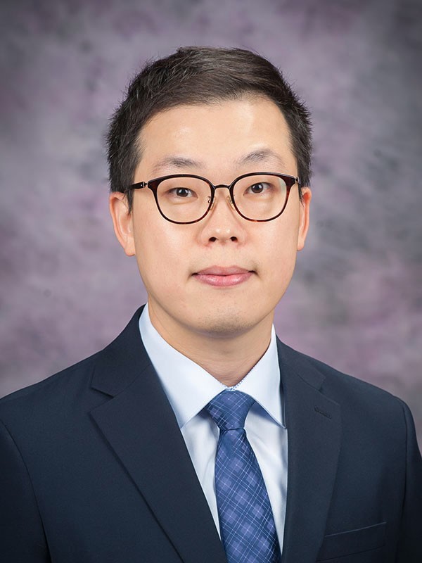 A photo of Dr. Rick Oh. He is wearing a blue tie and black blazer