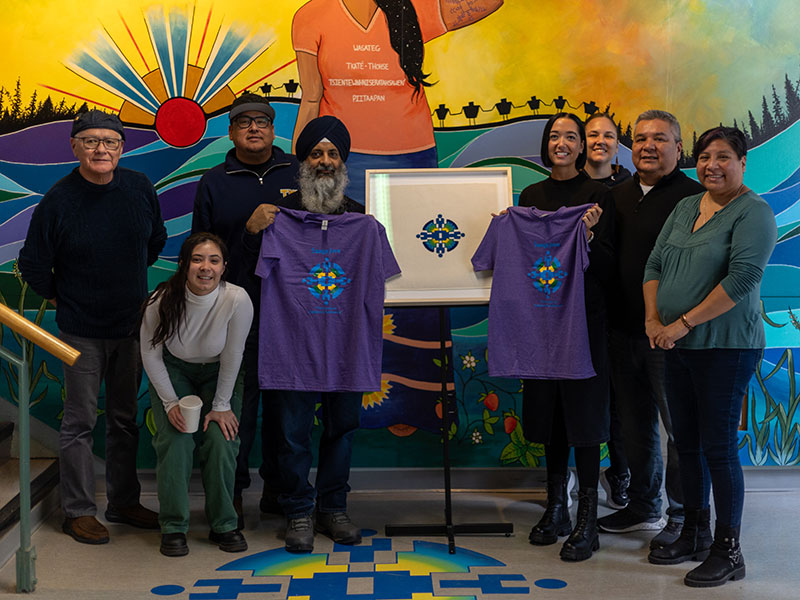 Community members, including T’hohahoken Michael Doxtater, Gabby McMann, Derek Sands, Joginder Singh, Justine Woods, Brian Norton, Amy Desjarlais and Carrie Davis gathered in front of Saagajiwe Totem and Saagajiwe mural