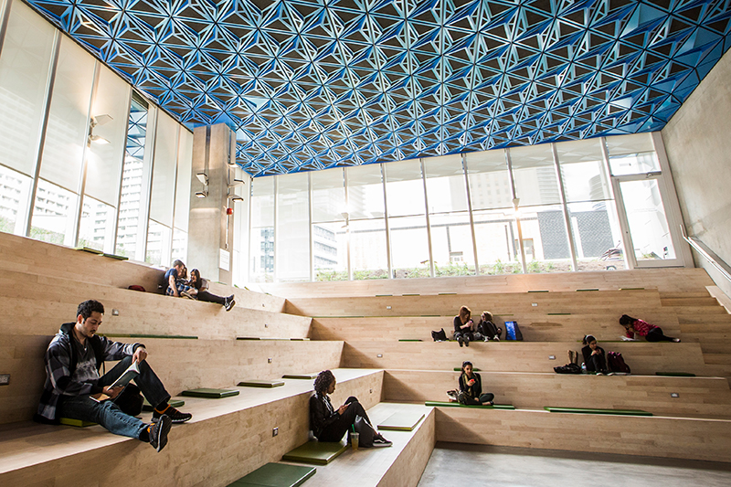 Groups of students studying while sitting on the benches in the SLC.