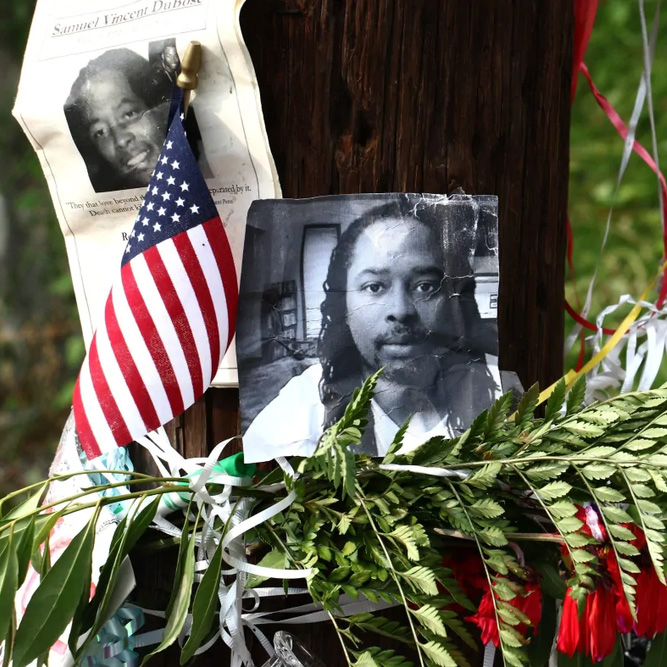 A memorial for Samuel DuBose in Cincinnati days after he was killed posted on a street post with an American flag and flowers
