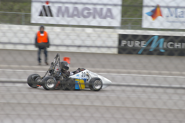 A student drives the Formula racing vehicle in a race