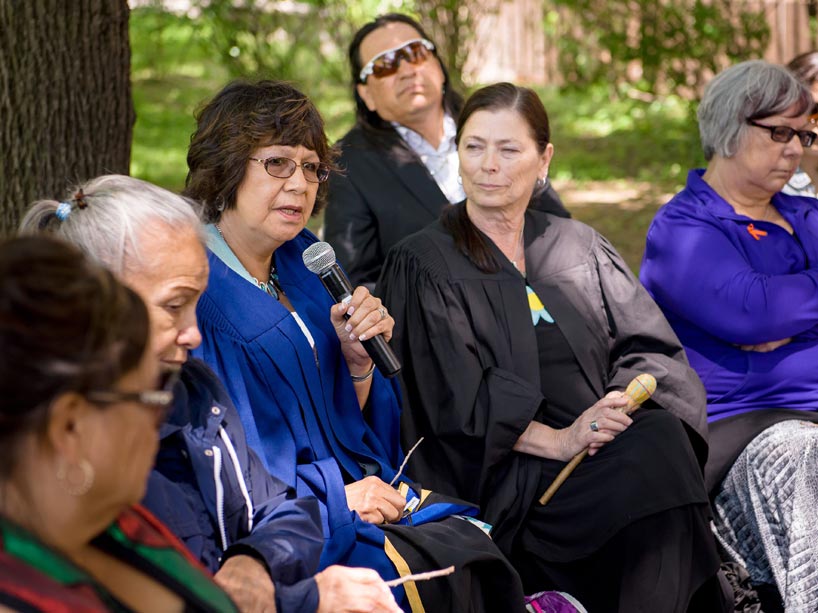 Vivian Timmins (left) speaks at a drum circle 