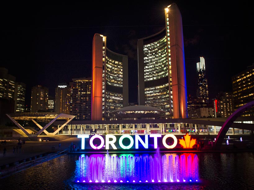 Toronto sign outside City Hall lit up with Ryerson's blue and gold colours