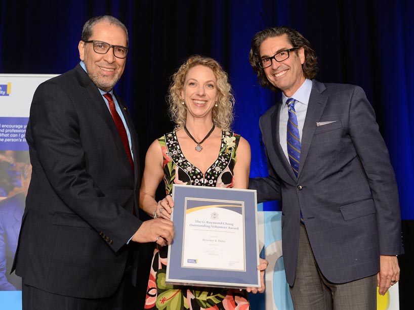 Bev Dales' daughter Michelle accepts an award for her mother from President Mohamed Lachemi and Ian Mishkel, vice-president, university advancement and alumni relations